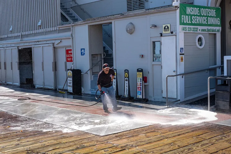 Pressure washer cleaning a paved surface